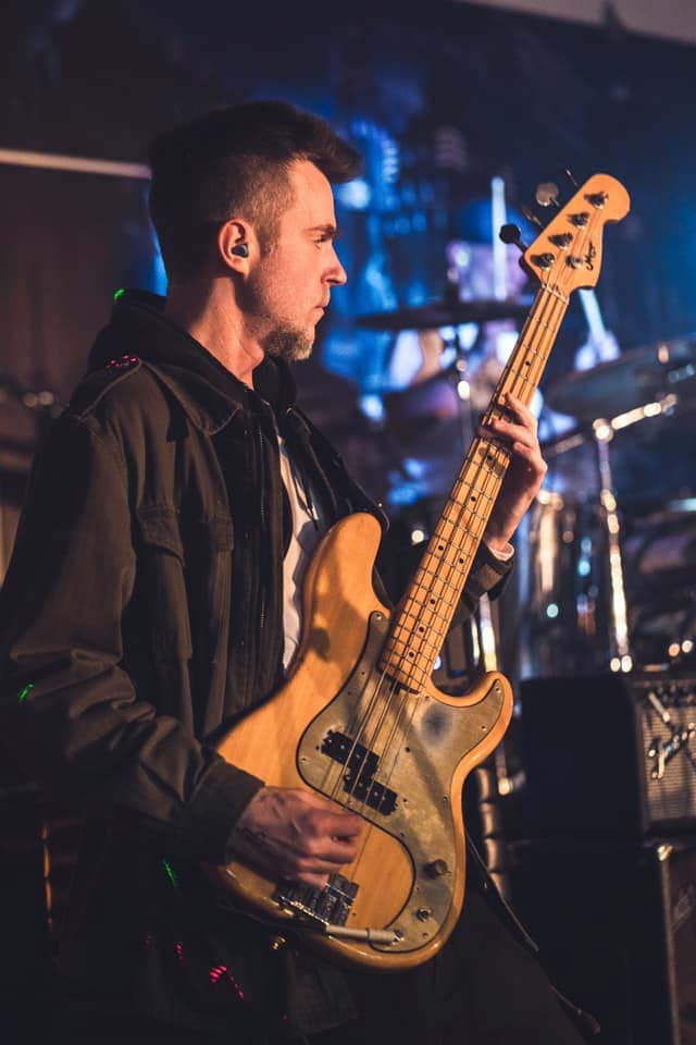 Dustin Sebes on a bass guitar at a performance